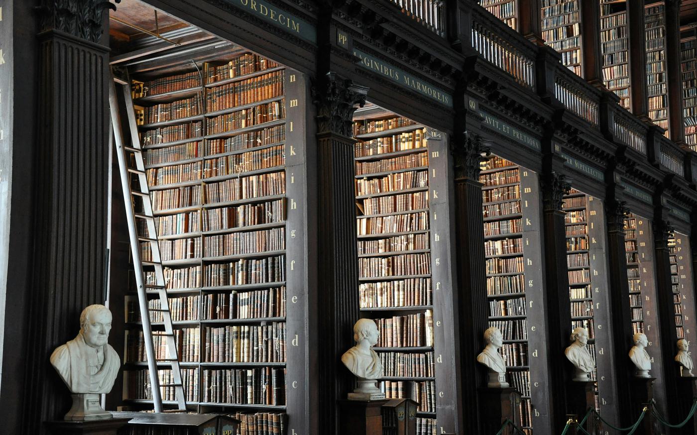 a library filled with lots of books and busturines by Alex Block courtesy of Unsplash.